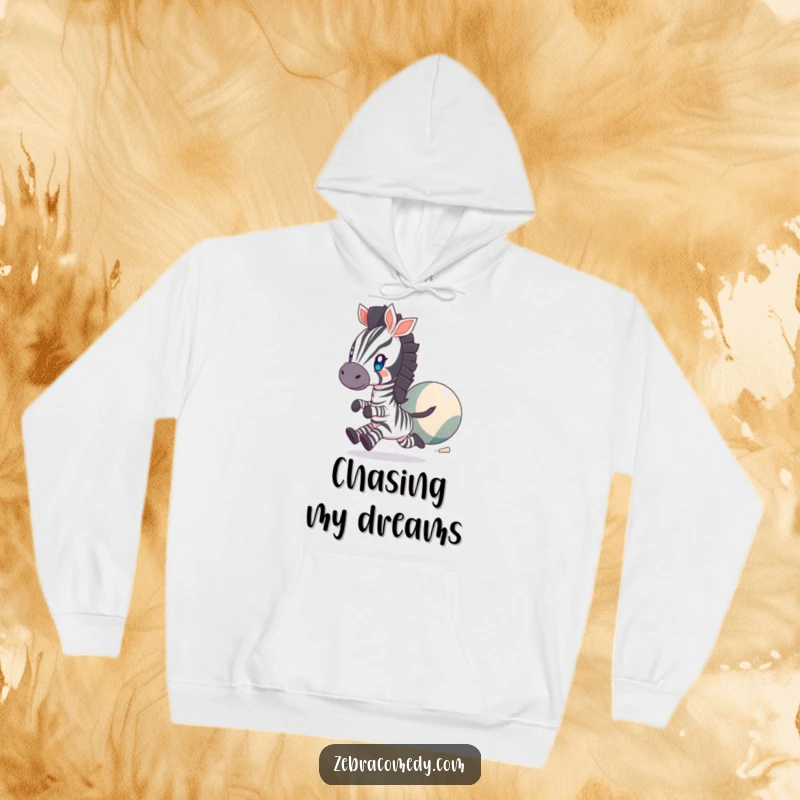 Funny Hoodie showing a zebra character with twinkling eyes, energetically chasing a huge bouncing ball, offering warmth and playful vibes.